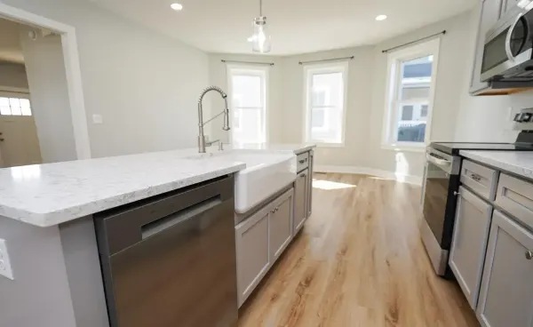 Finished kitchen with farmhouse sink and quartz island